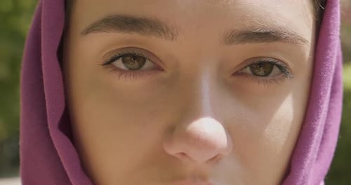Schöne junge Frau blickt in die Kamera und trägt ein traditionelles Kopftuch. Attraktive Frau im Hijab