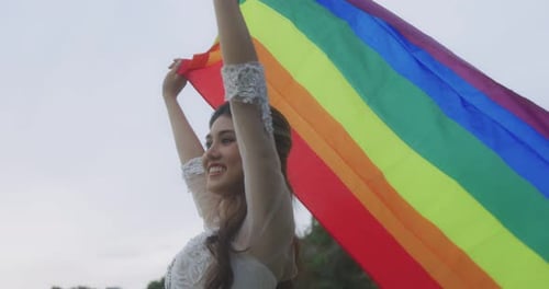 Woman Celebrates Love with Rainbow Flag Outdoors