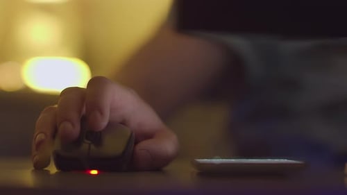 A Man Answers a Mobile Phone Call Works on a Computer Through a Wired Mouse Closeup