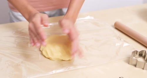 Hands Flattening Dough for Baking Cookies