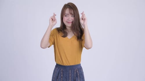 Young Woman Crossing Fingers with Hopeful Expression