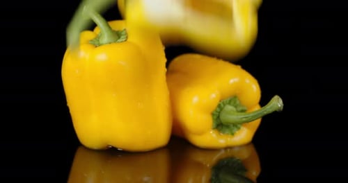 Halbe gelbe Paprika fällt mit einem Spritzer ins Wasser.