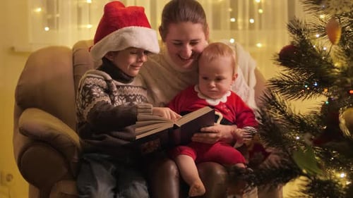 Mother and Children Reading Book at Christmas
