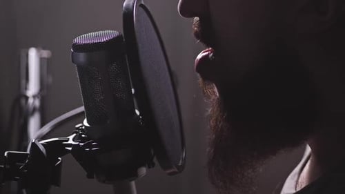 A Microphone in the Studio a Man Appears Starts Reciting or Humming