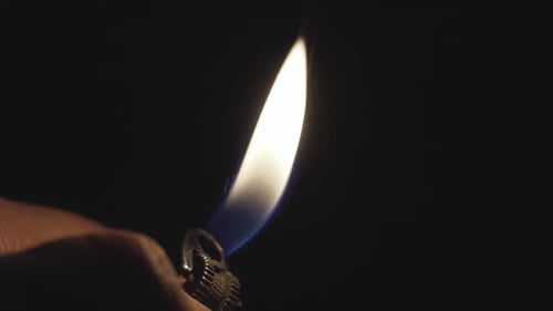 Plan rapproché au ralenti d'un briquet sur la main de l'homme