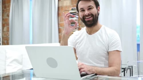 Man at Computer Gives OK Sign