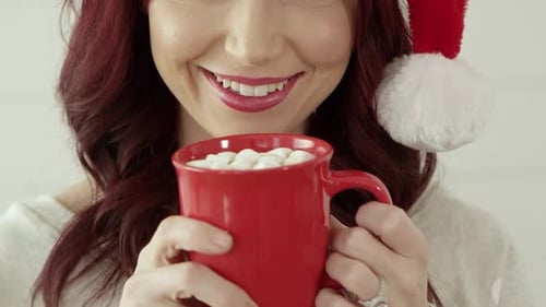 Woman Smiling with Hot Chocolate in Santa Hat