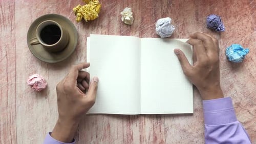 Crumpled Paper Ball and Notepad on Wooden Table