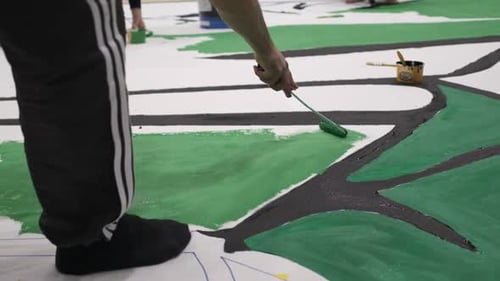 Adults Painting an Art Design on a Floor
