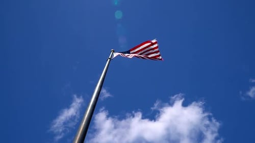 American Flag Waving Proudly Against Blue Sky