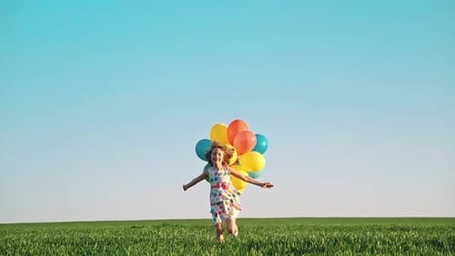 Girl Running with Balloons in a Grassy Field