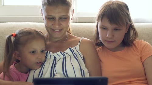 Mother and Daughters Watching a Tablet at Home