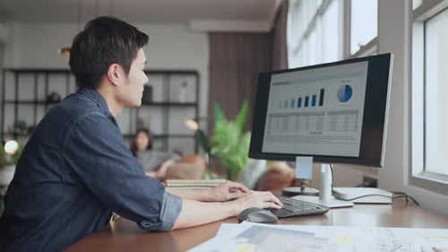 Young Adult Works at Computer at Home Office