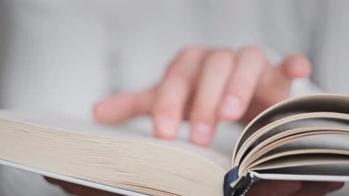 Reading a Book and Turning the Pages Close Up Slow Motion