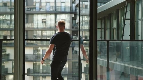 Man Dancing on Balcony in City Apartment