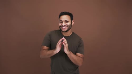 Positive Indian Guy Dancing Funny Moves Enjoying Music Over Brown Background Slow Motion