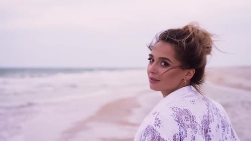 Girl Walks on the Beach on the Background of the Sea