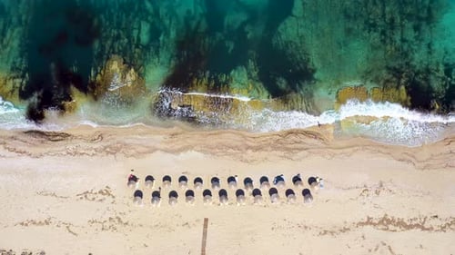 Umbrellas lined up on the sandy beach by the turquoise sea.