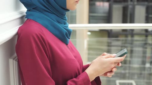 Nahaufnahme der Hände der muslimischen Mädchen mit einem Smartphone