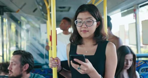 Bus Stands at Bus Stop in City Center Woman with Glasses Using Public Transportation Holds