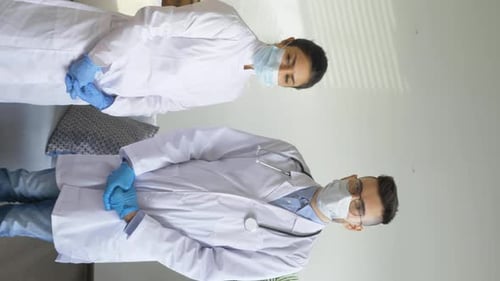 Doctors in Masks and Gloves Standing Indoors