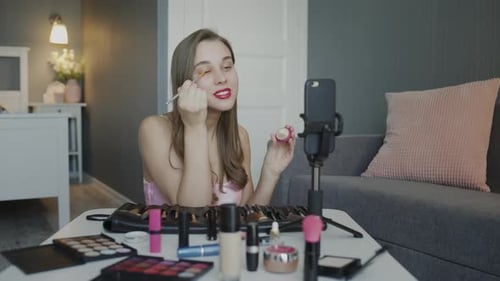 Beauty Blogger presenta cosméticos de belleza mientras está sentado frente a la cámara para grabar Vídeo.
Mujer