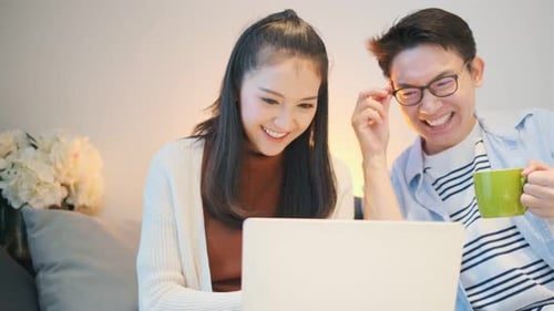 Smiling Couple Using Laptop at Home