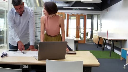 Business people discussing over blueprint in modern office 4k