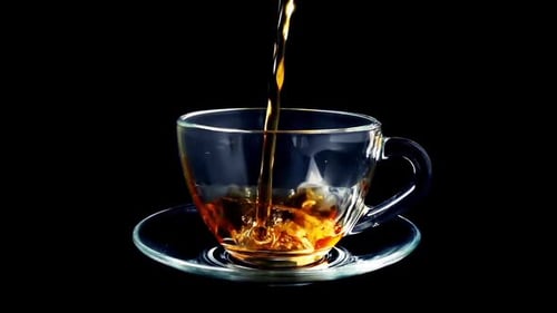 Pouring Tea into a Clear Glass Cup