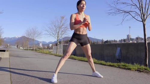 Woman Stretching Outdoors on Sunny Day