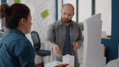 Woman Brainstorming Ideas with Man to Design Building Model Plan and Blueprints