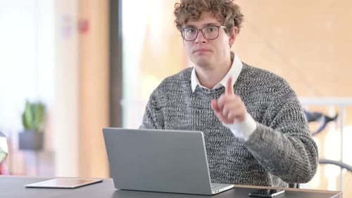 Young Adult Says No While Working at Laptop