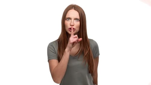 Porträt einer hartnäckigen, strengen Frau aus den Zwanzigern, die den Zeigefinger auf den Lippen hält und darum bittet, still zu bleiben