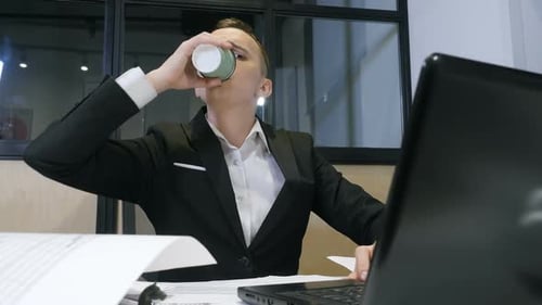 Man Drinking a Coffee at Office. Young Businessman At Work.