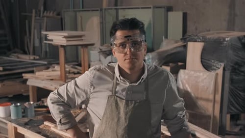 Carpenter in Workshop Wearing Safety Goggles and Apron