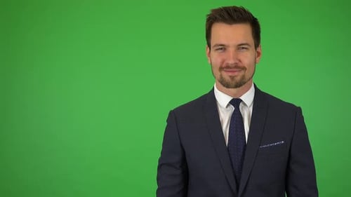 A Young Handsome Businessman Smiles at the Camera - Green Screen Studio