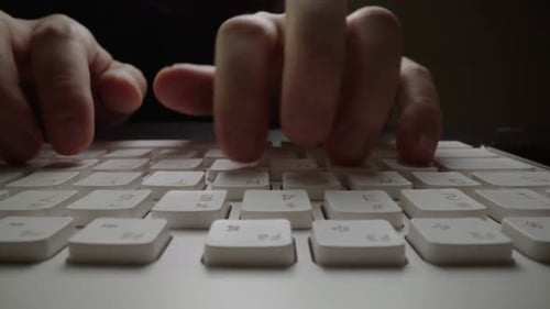 Tippen in Nahaufnahme auf der Tastatur mit den Hauptfingern. Makro-Dolly-Aufnahme mit weichem Fokus
.