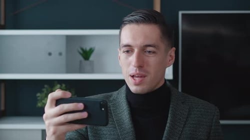 Happy Businessman Making Facetime Video Calling with Smartphone at Modern Office Greeting People on