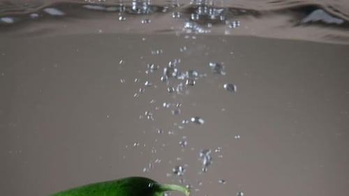 Cucumbers Dropping into Water with Bubbles