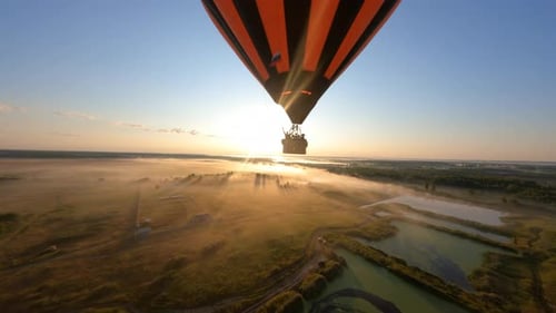 globo aerostático flotando sobre el campo inclinado en el hermoso amanecer