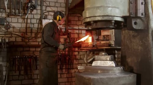 Blacksmith Shaping Hot Metal Object With Machine