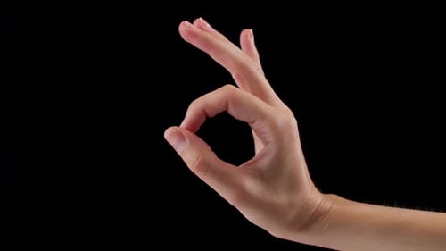 Woman's Hand Showing OK Sign Okay Gesture Isolated on Black Background in Studio