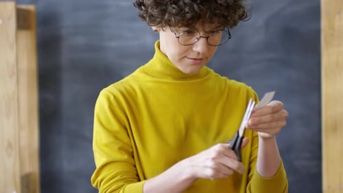 Person Cutting Colorful Shapes with Scissors
