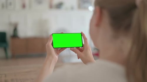 Rear View of Beautiful Woman Holding Smartphone with Green Screen