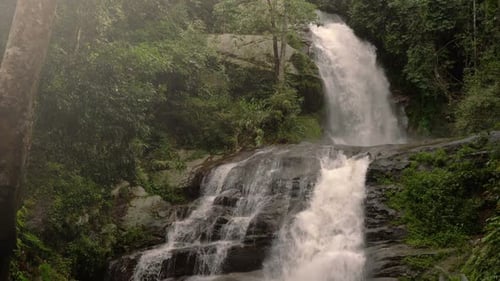 Tropical Waterfall Flowing Through Lush Green Nature