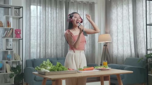 Woman Dancing and Singing While Chopping Vegetables