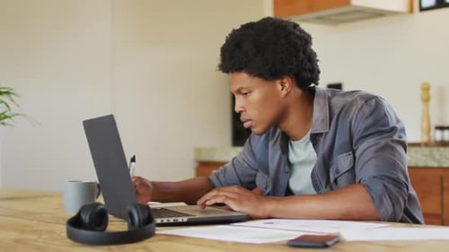 Young Adult Working at Laptop in Bright Home
