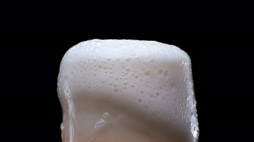 Foamy Beer in Glass on Black Background