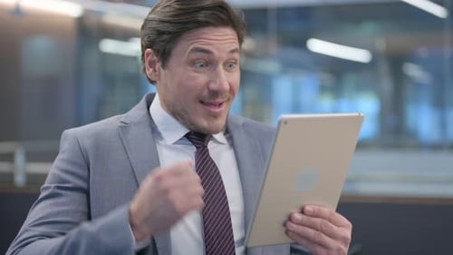 Portrait of Middle Aged Businessman Celebrating Success on Tablet