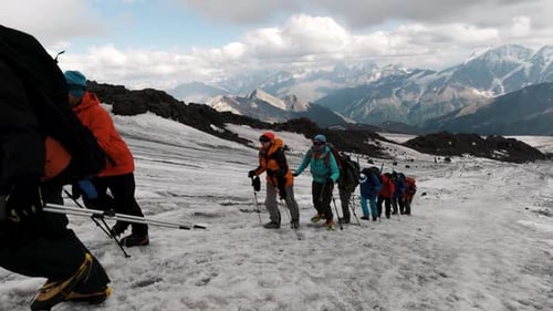 Travelers rise along the mountain pass on the ice slope